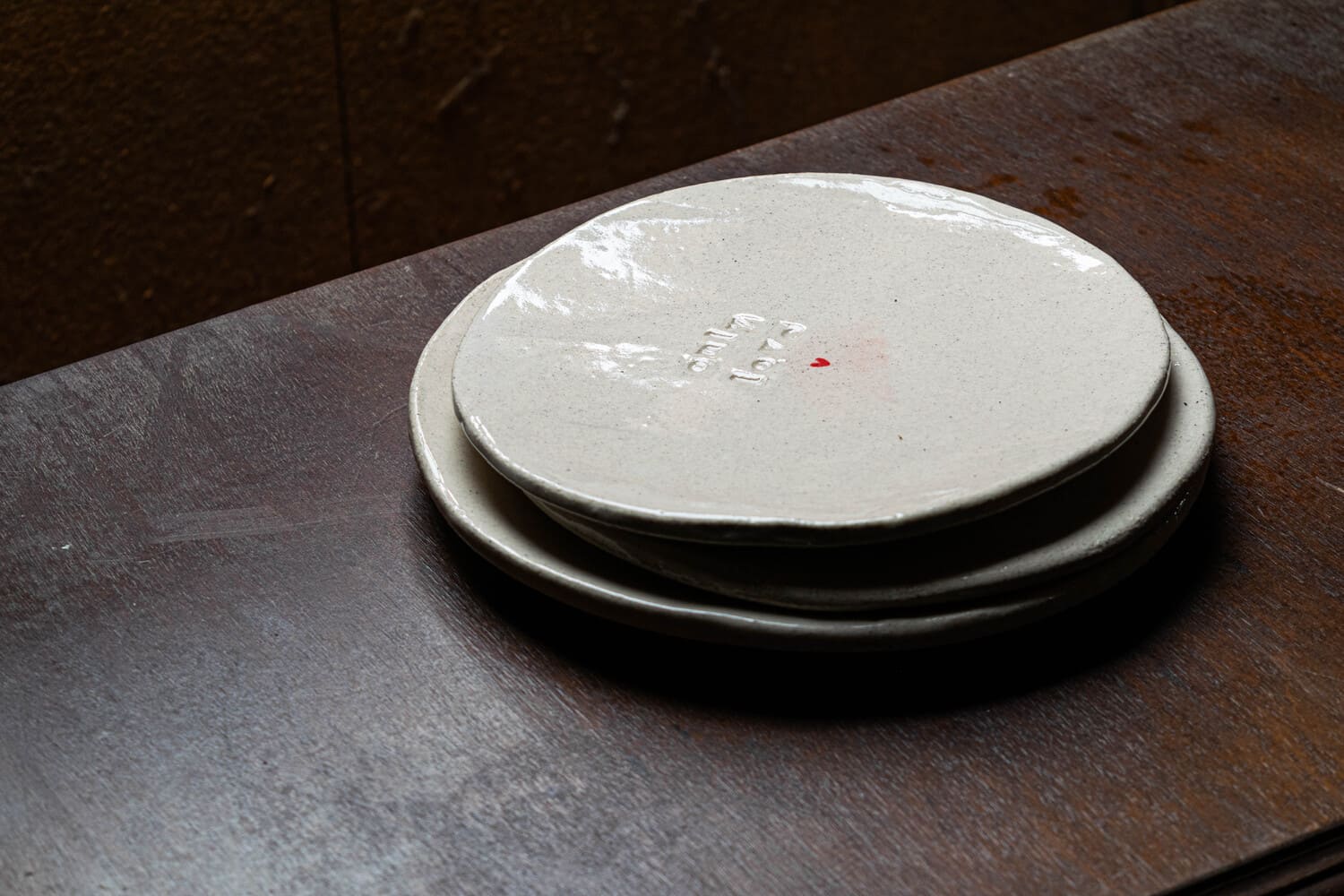 Petite assiette avec un cœur rouge au milieu et "Only Love" gravé.